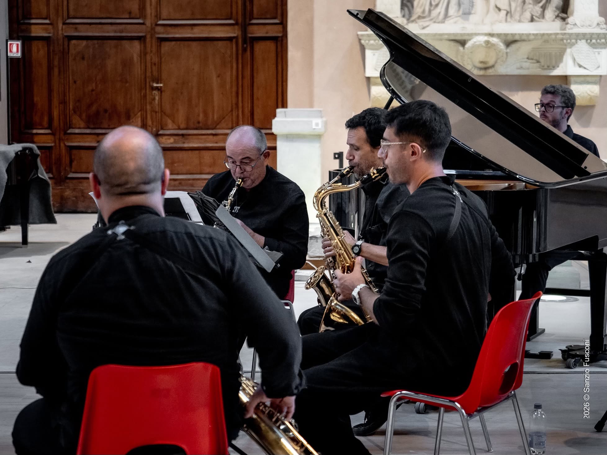 Sidera Saxophone Quartet playing together in a concert hall.